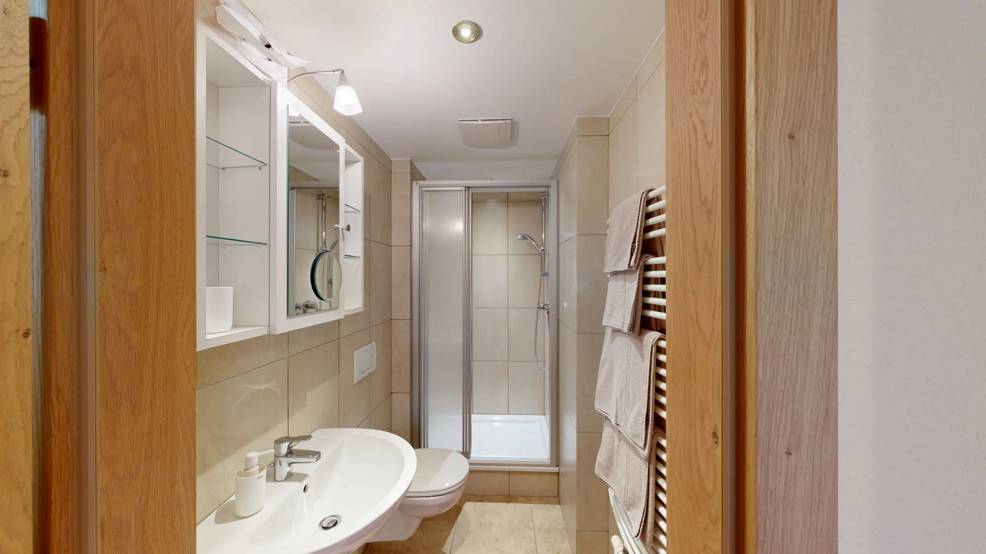 modernes Badezimmer mit Dusche, Waschbecken und Handtüchern
